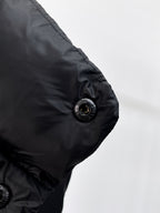 Close-up of dark puffer vest arm with round snap button