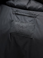 Close-up of rectangular fabric label inside dark puffer vest
