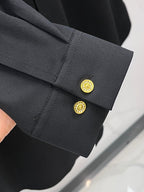 Black shirt cuff with gold buttons and stitched sleeve edge detail