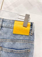 Denim pants close-up: yellow GALLERY DEPT. leather patch at waistband