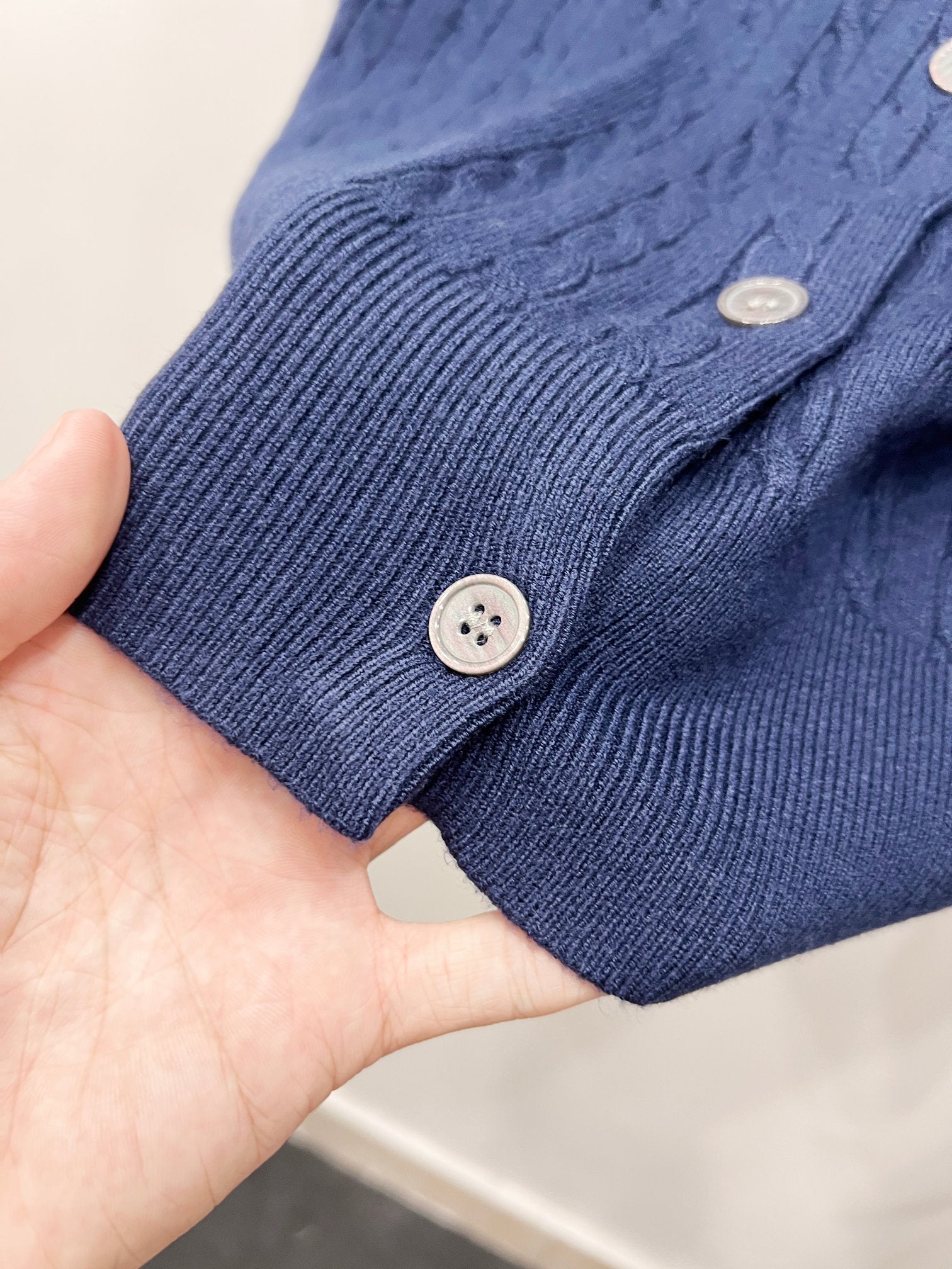 Blue rib-knit cardigan cuff with button closure