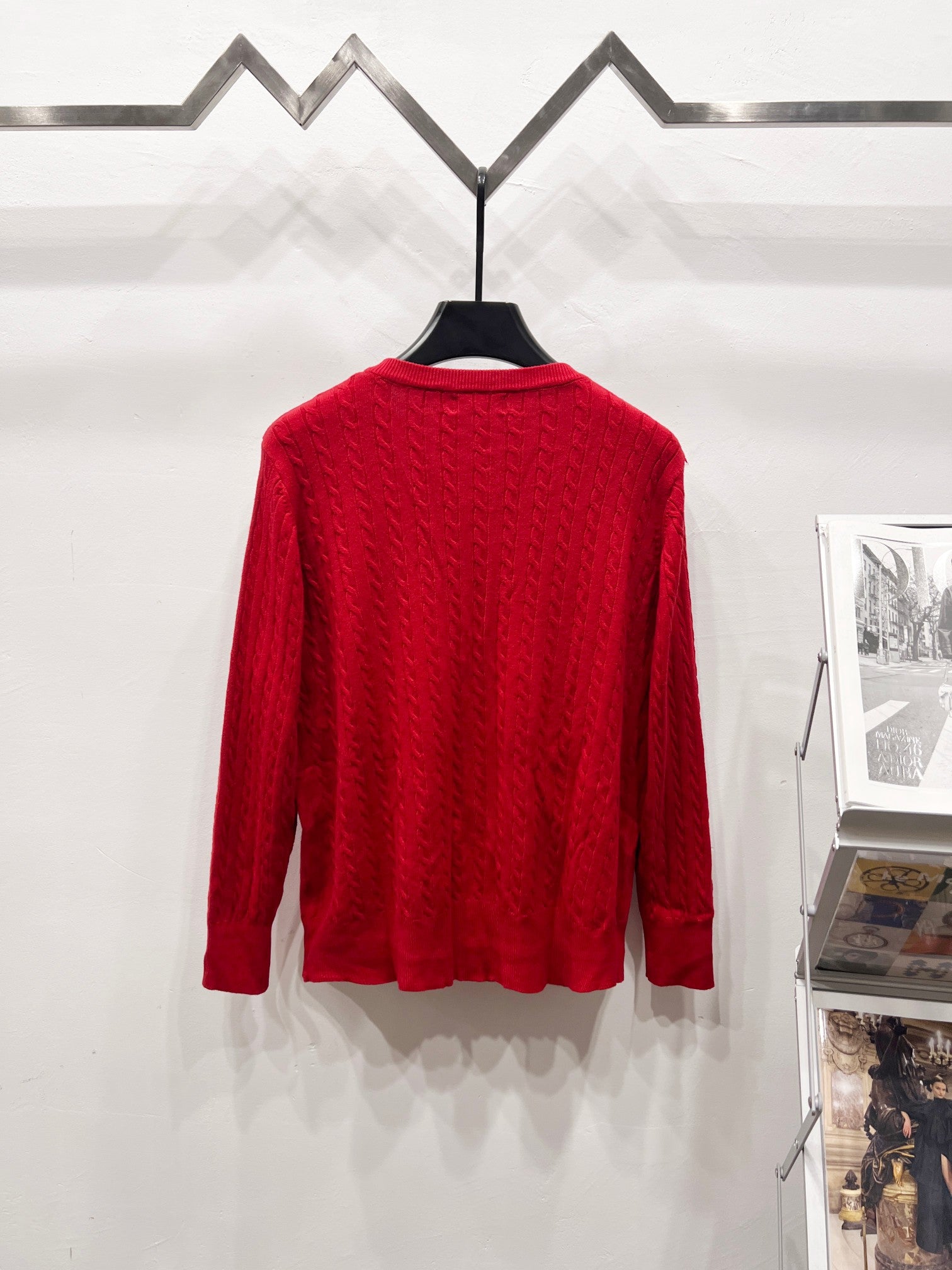 Red cable-knit cardigan sweater back view on hanger