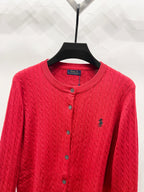 Red cable-knit cardigan sweater with button placket and small horse logo