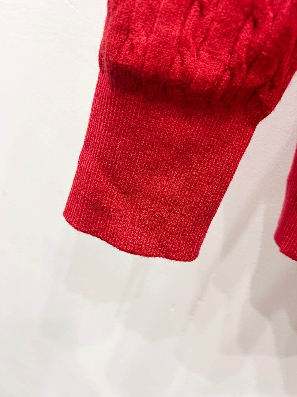 Red ribbed knit cardigan hem and sleeve cuff detail