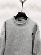 Gray crewneck knit sweater with small black emblem on right shoulder