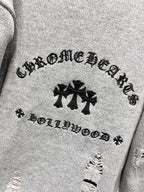 Gray knit sweater close-up of decorative text and black leaf-like logo