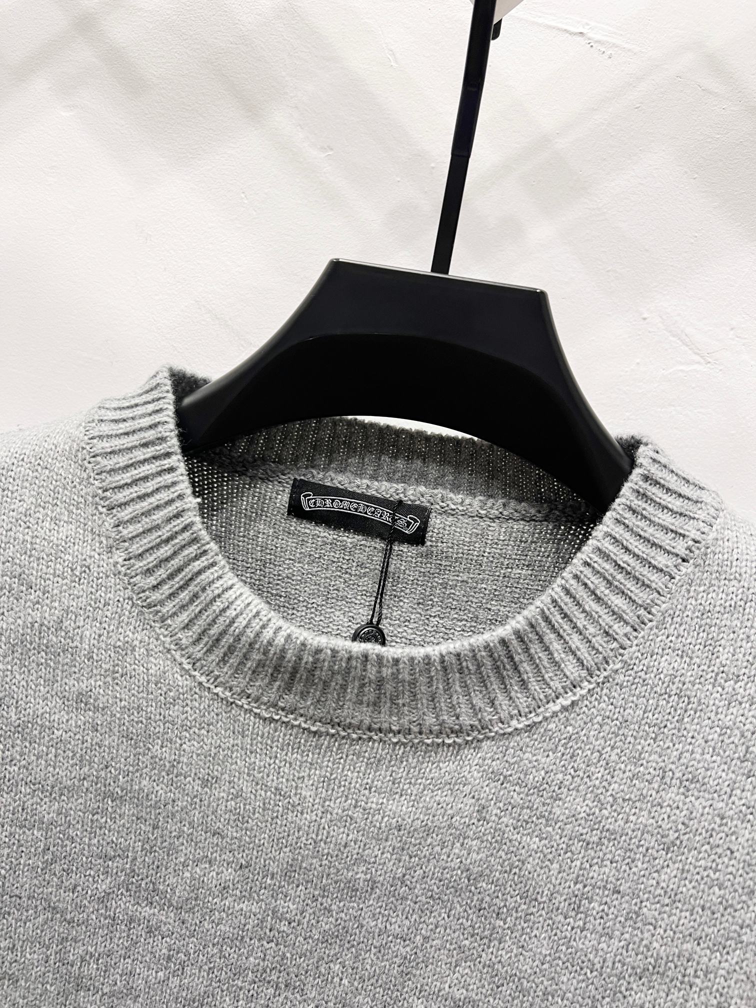 Gray crewneck sweater collar with inner label visible