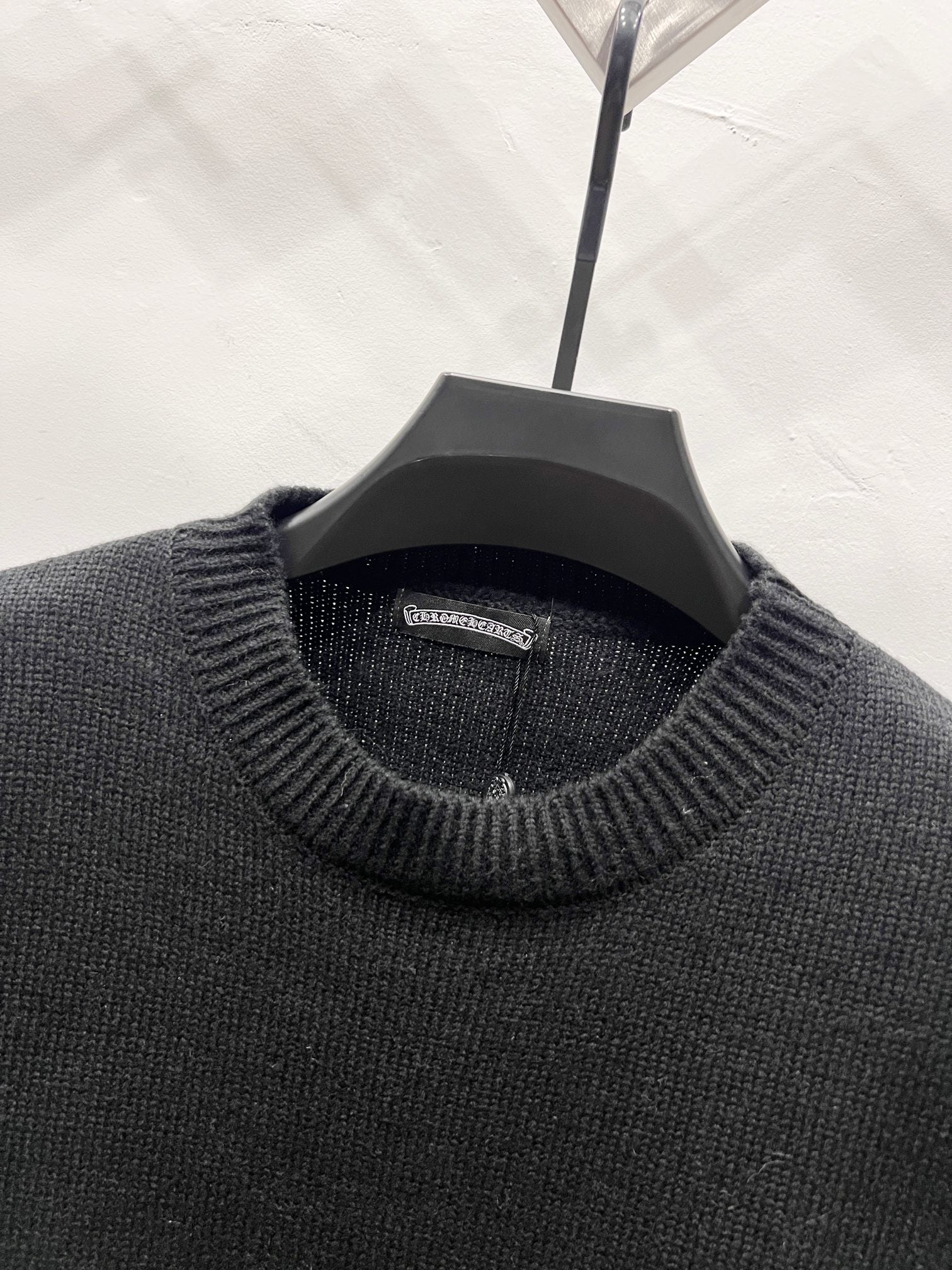 Black knit sweater neckline with ribbed collar and interior brand label