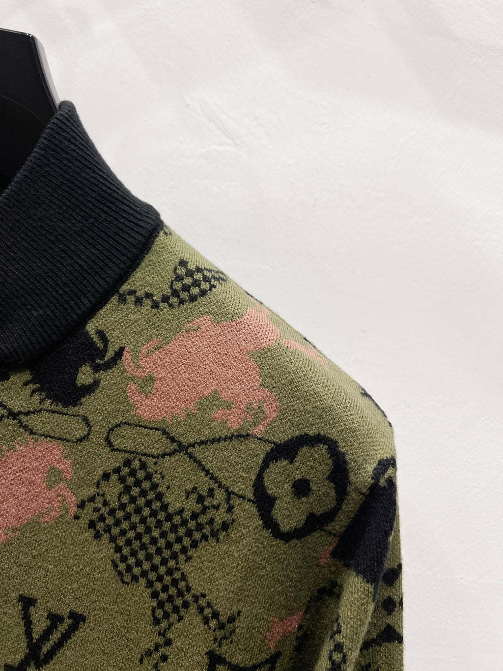 Zip-up jacket sleeve with multicolor monogram knit on olive background