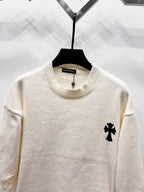 Cream long-sleeve sweater with ribbed crew neck and small black clover patch on chest