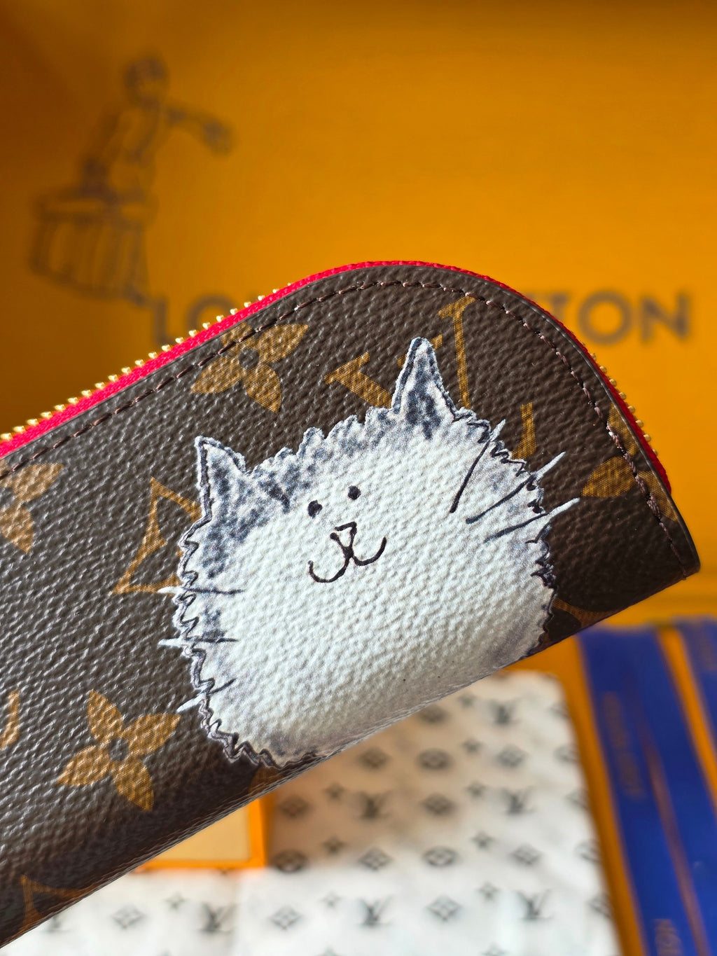 Louis Vuitton small bag close-up: cat face patch on dark monogram with pink trim
