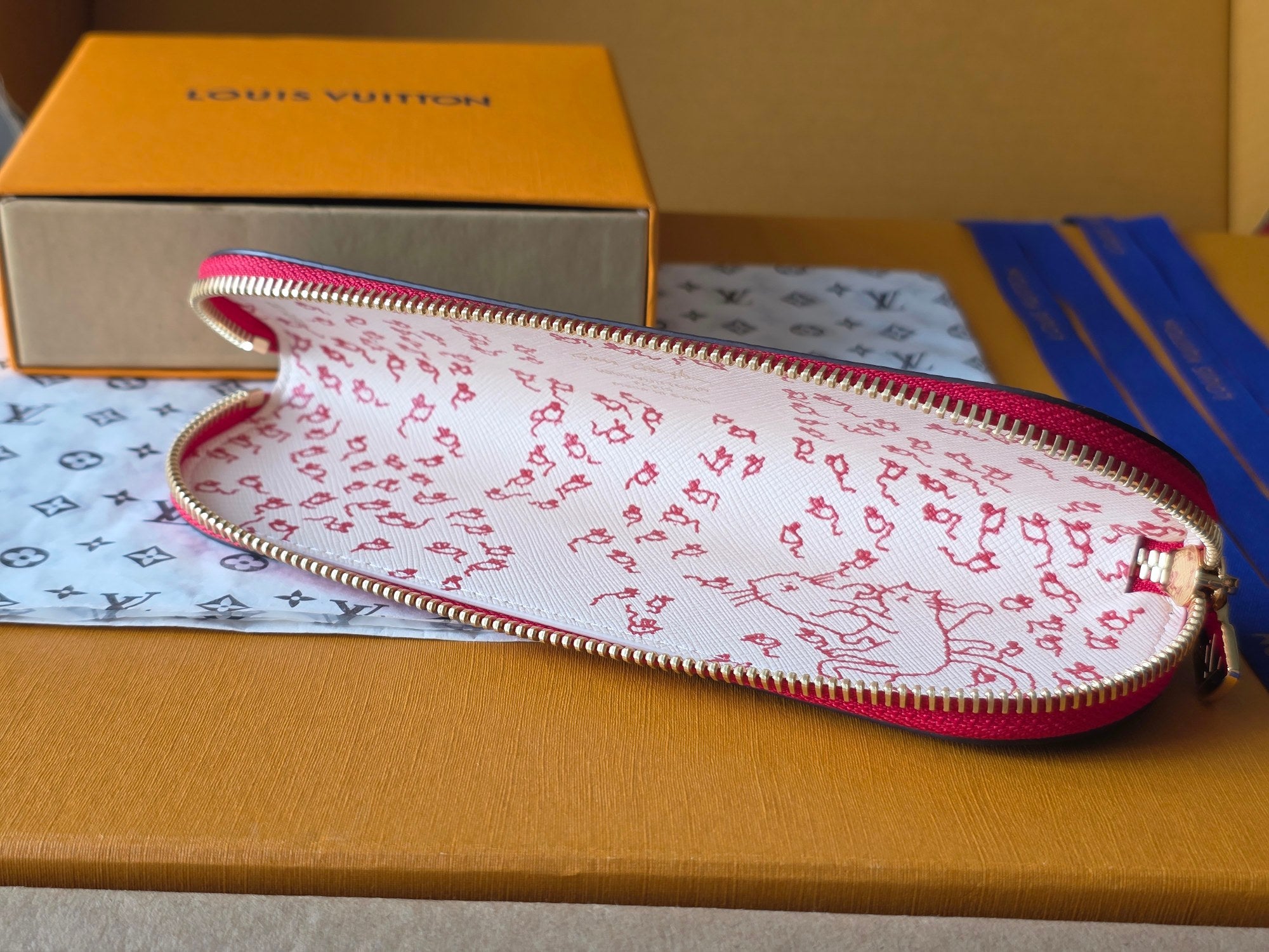 Louis Vuitton small bag with white-and-red repeating pattern and pink zipper trim