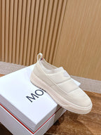 Moncler white slip-on sneaker resting on a white shoebox