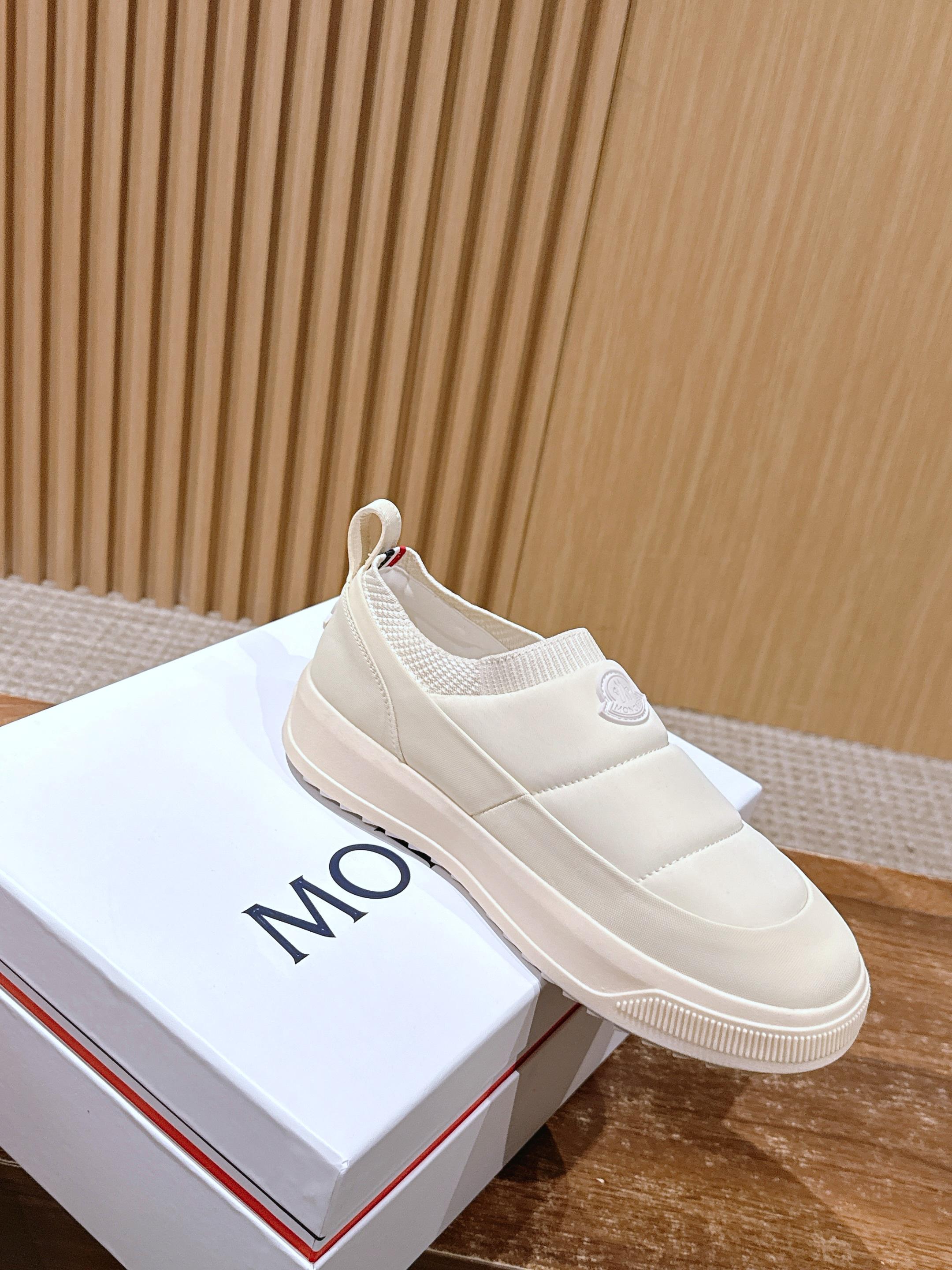 Moncler white slip-on sneaker resting on a white shoebox