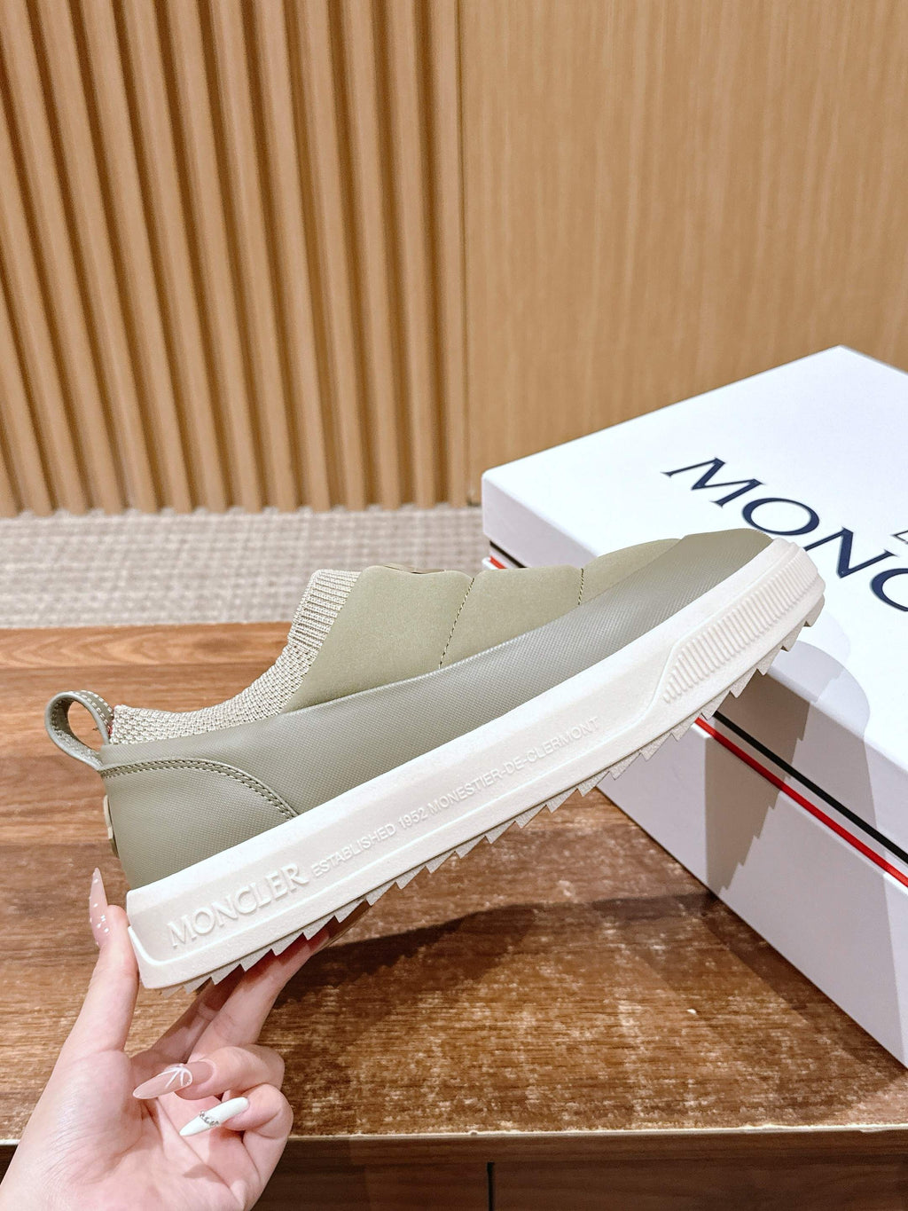 Moncler light beige slip-on sneaker showing textured white sole edge and stitched upper