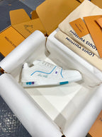 White Louis Vuitton trainer shoe with blue outline stitching and logo on the side.
