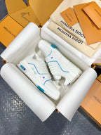 White Louis Vuitton trainer shoes with blue trim, lace details, and textured side panels.