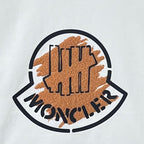 Moncler logo patch on white sweatshirt with brown textured print and black outline