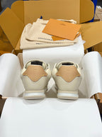 Back view of cream low-top sneakers with tan heel tabs and white rubber midsoles