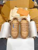 Tan lace-up low-top sneakers with logo detail on tongue and side panels