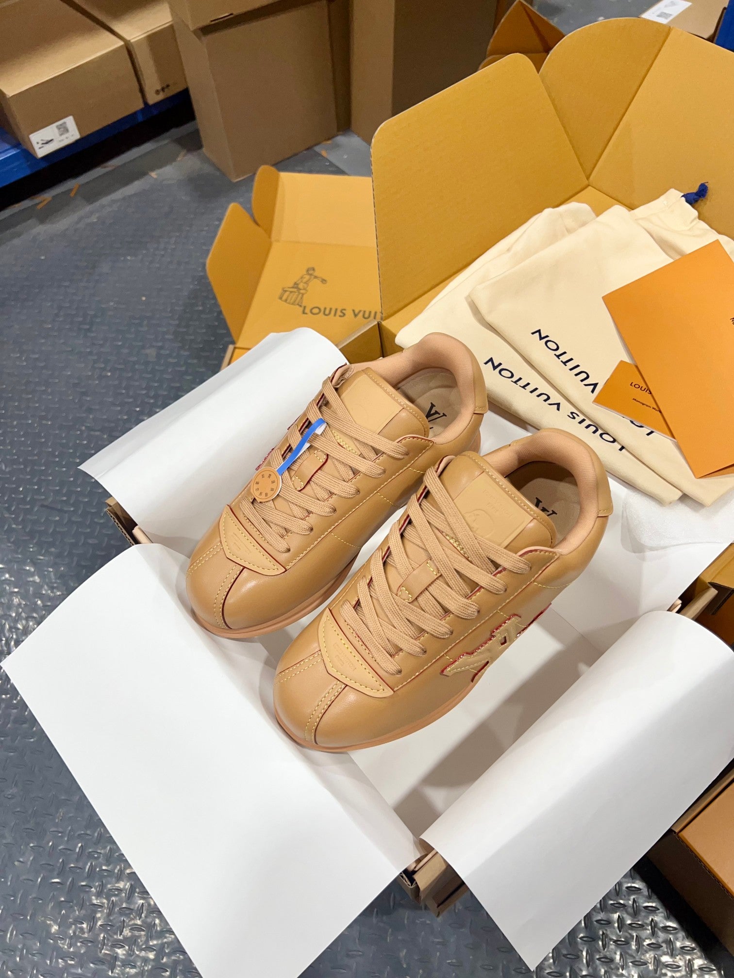 Tan lace-up low-top sneakers, overhead view showing woven laces and side logo