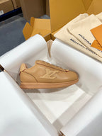Tan low-top sneakers with embossed side logo and gum-colored midsole