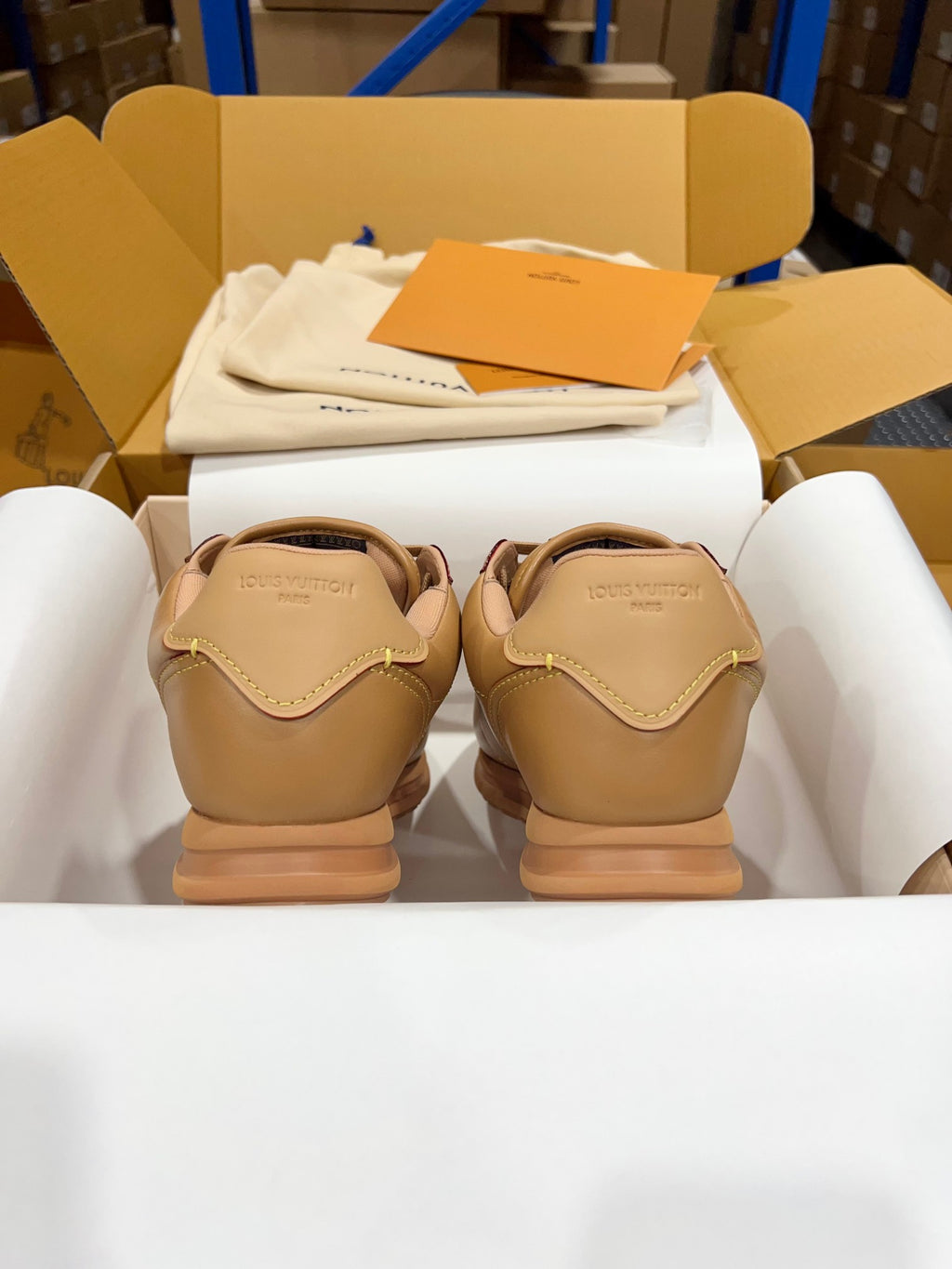 Tan leather low-top sneakers, rear view with stitched heel details
