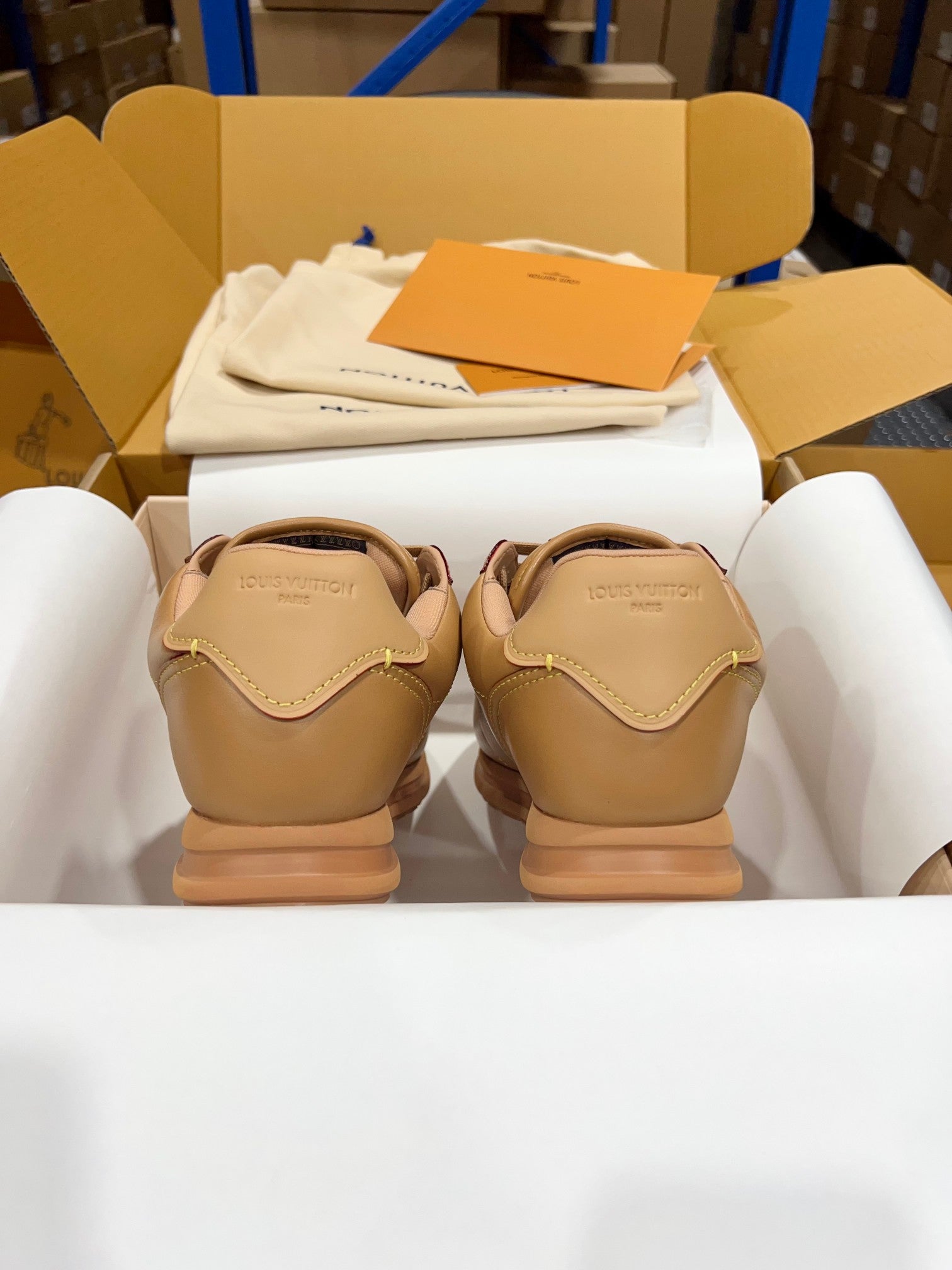 Tan leather low-top sneakers, rear view with stitched heel details