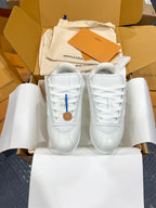 Louis Vuitton white lace-up sneakers on tissue paper, featuring stitched side panels