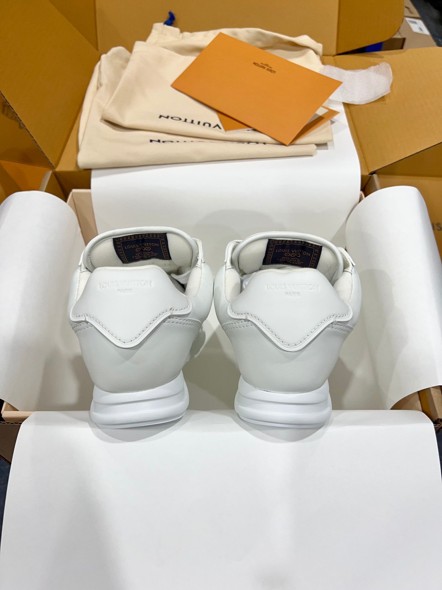 Louis Vuitton white sneakers shown from the back with cushioned heel and rubber sole