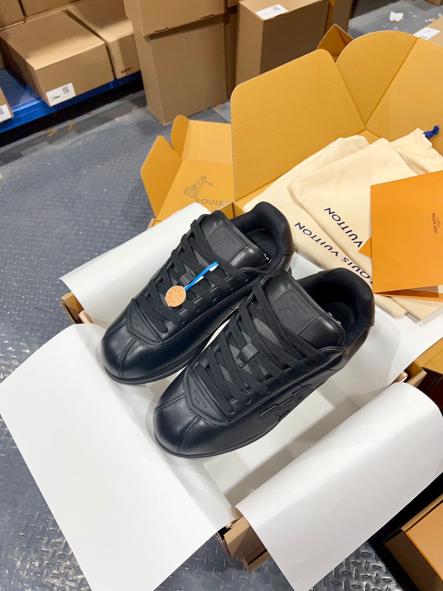 Black Louis Vuitton lace-up sneakers with side logo details, angled view