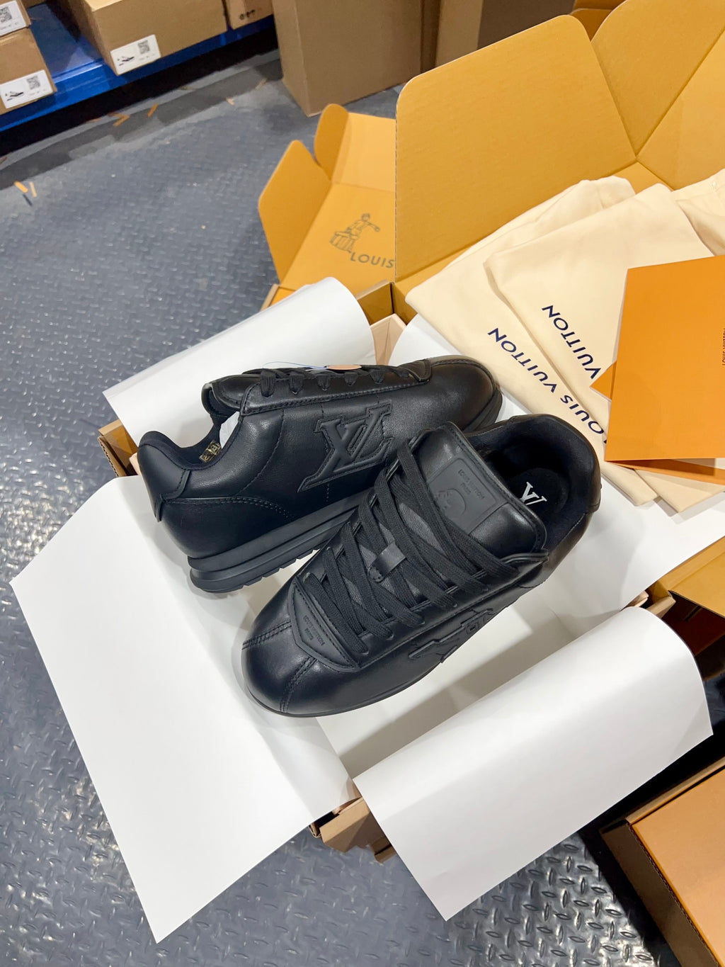 Black Louis Vuitton low-top sneakers with embossed LV-style logo and lace-up front