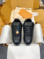 Pair of black Louis Vuitton lace-up sneakers on white tissue paper, flat view