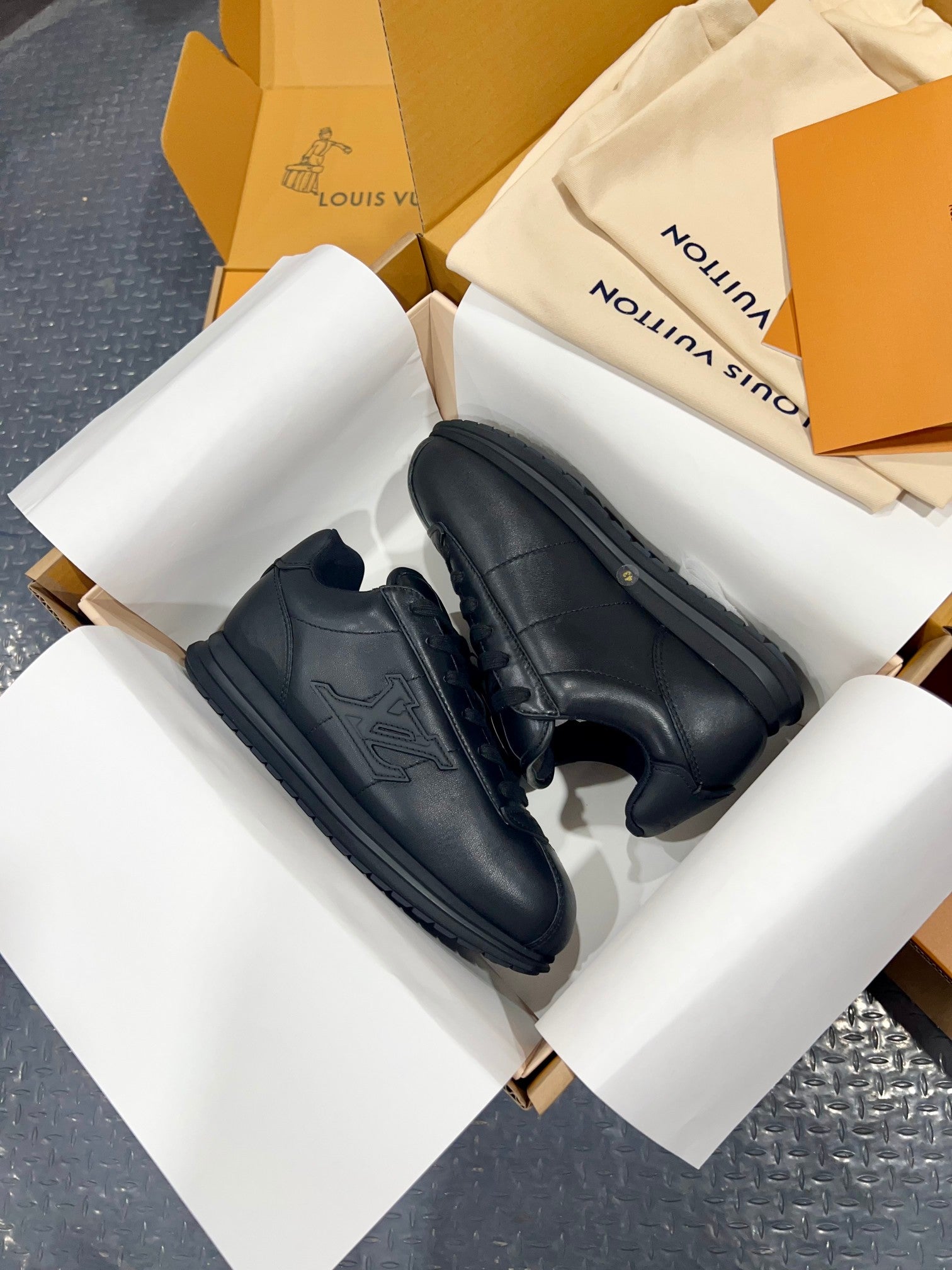 Black Louis Vuitton sneakers with side stripe panels and thick rubber sole, side view