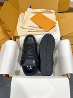 Black Louis Vuitton lace-up sneakers with treaded rubber sole, bottom visible
