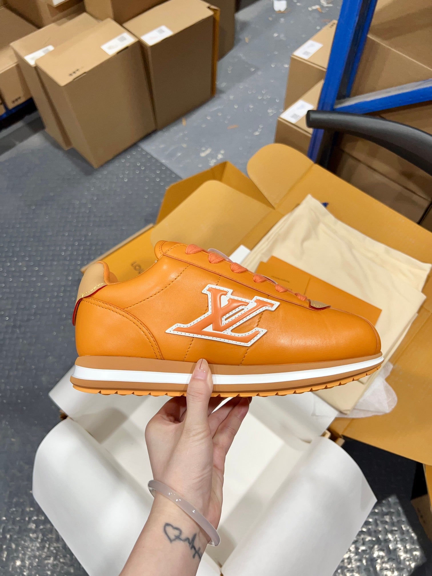 Louis Vuitton unisex sneakers, orange leather with white LV logo and blue lace accents