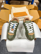 Green leather sneakers with white laces and tan side panels, LV logo visible