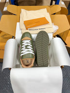 Green leather sneakers with white laces, showing treaded outsole in box