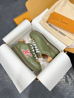Green leather sneaker with white laces and red LV logo, shown at angle