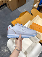 Light blue leather sneakers with lace-up front and blue striped sole detail