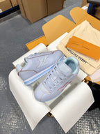 Light blue sneakers with side LV logo emblem, laces, and blue striped sole