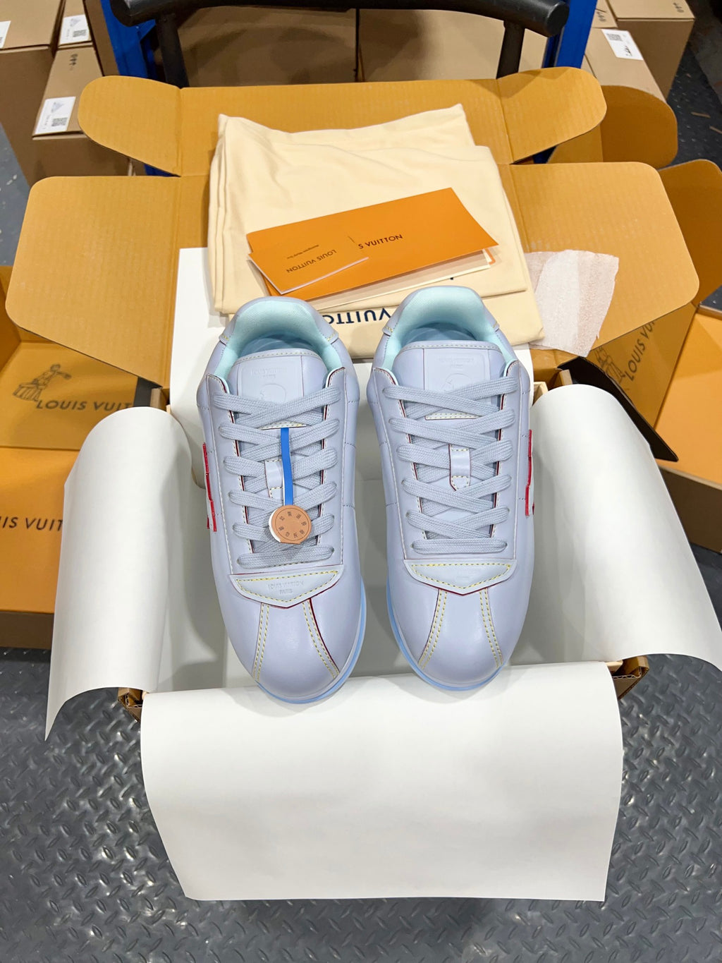 Pair of light blue lace-up sneakers with logo patch and blue-striped rubber sole
