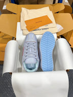 Light blue sneaker showing treaded blue sole and lace-up upper in box