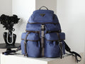Prada blue nylon backpack with top flap and front pockets, dual straps