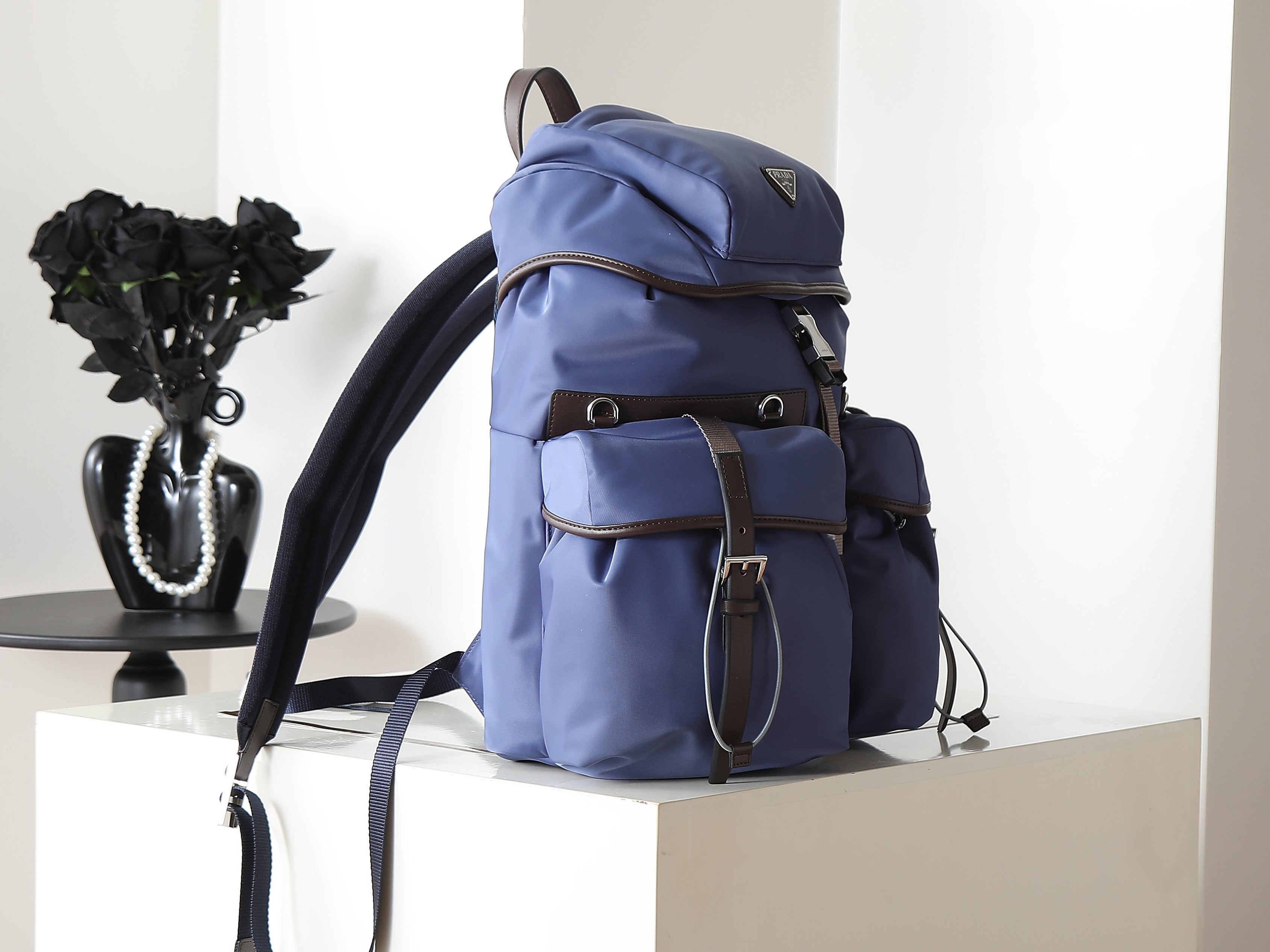 Prada blue nylon backpack from side angle with adjustable shoulder strap