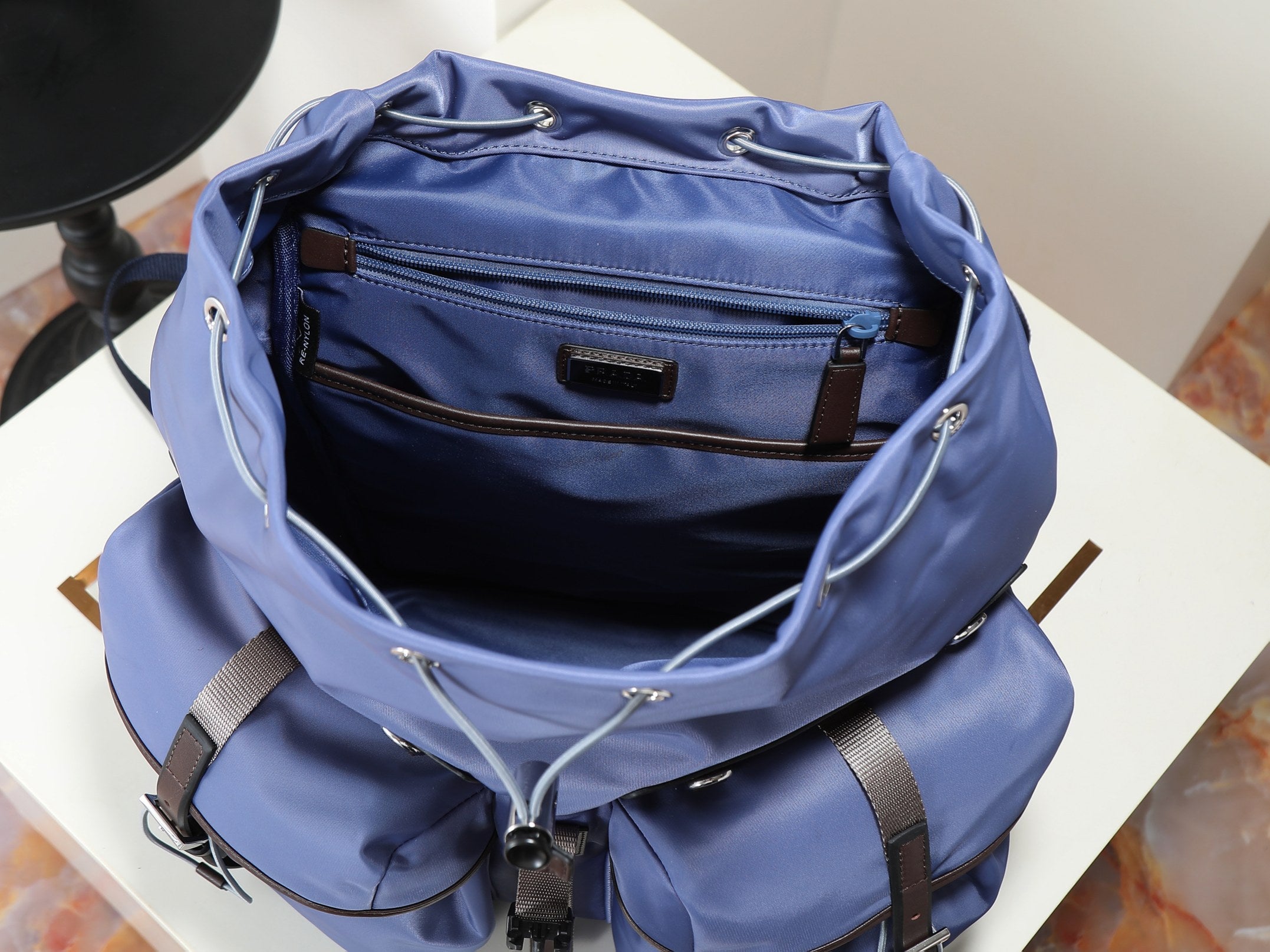 Prada blue nylon tote opening with inner zip pocket and leather logo tabs