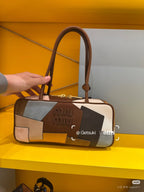 Patchwork leather bag with curved top handles, multicolor panels, and front logo patch detail.