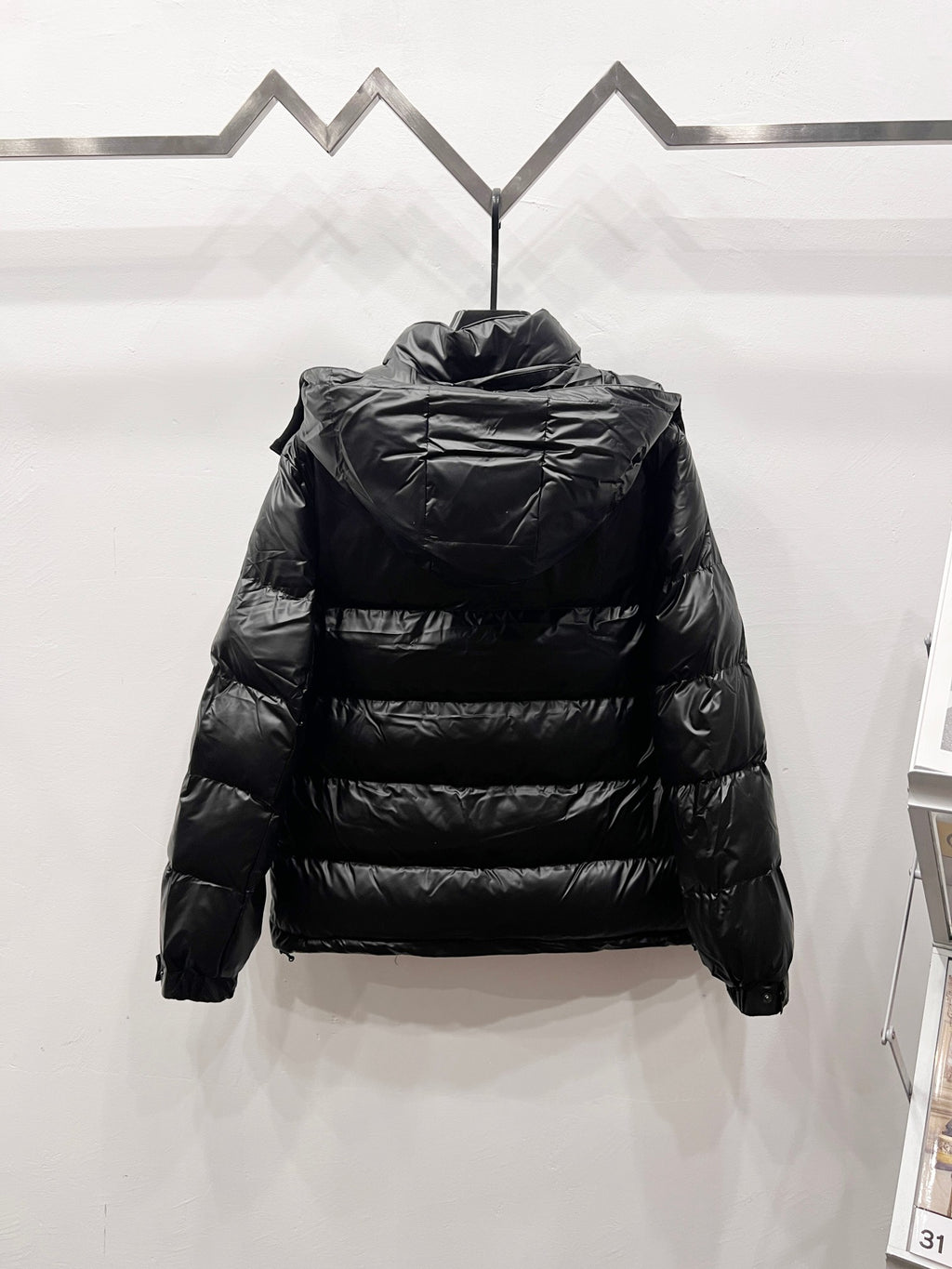 Black long puffer jacket back view with high collar and quilted horizontal stitching