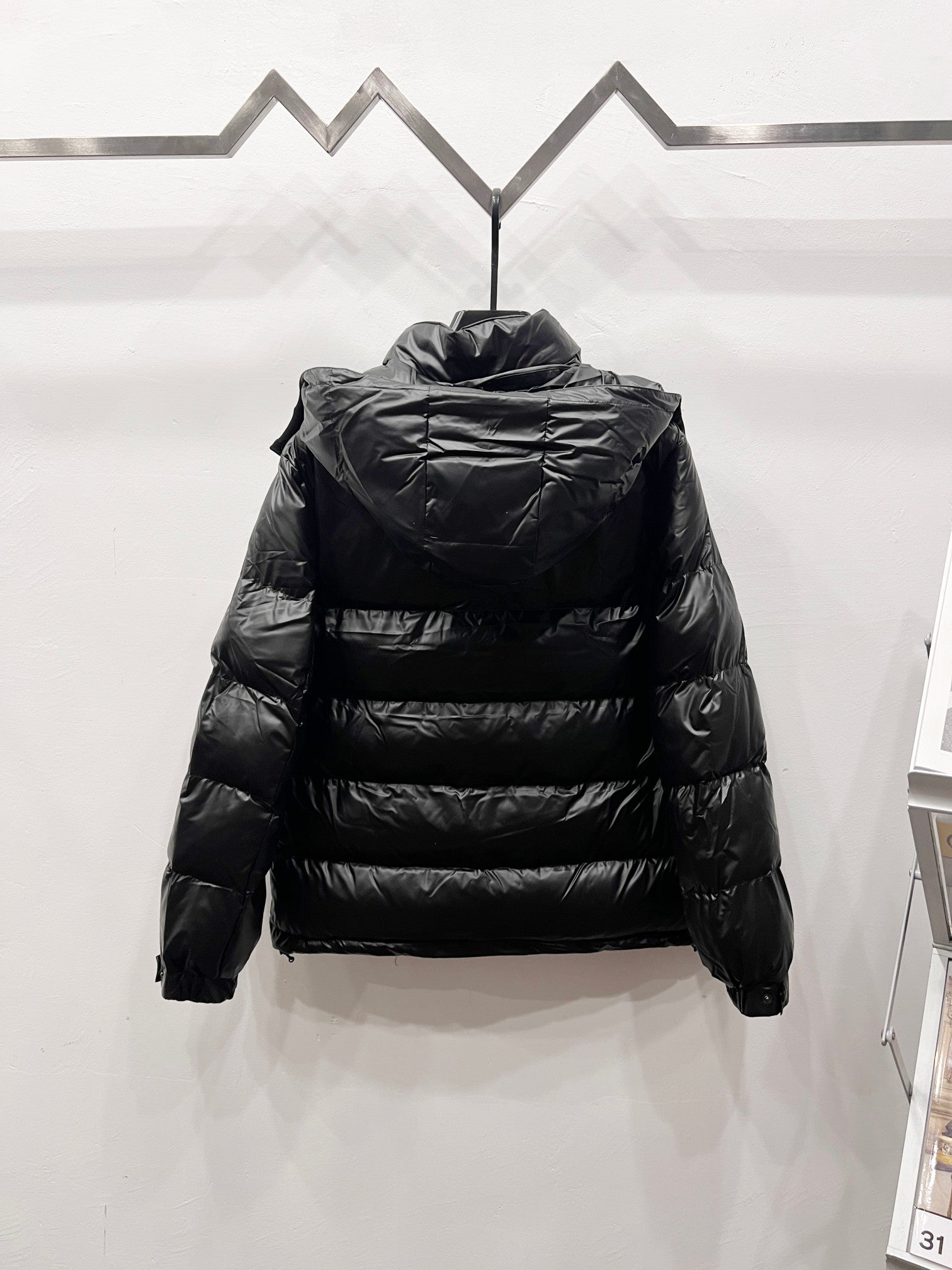 Black long puffer jacket back view with high collar and quilted horizontal stitching