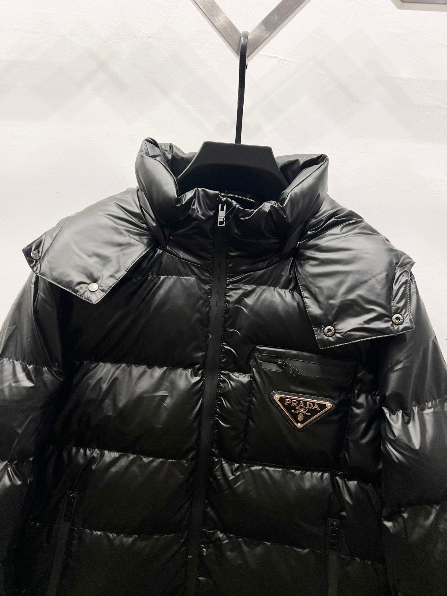 Black long puffer jacket with logo patch on chest and high neck collar